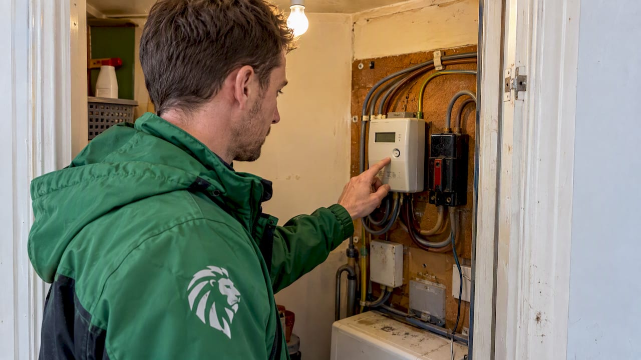 Worker checking UK prepayment electricity meter